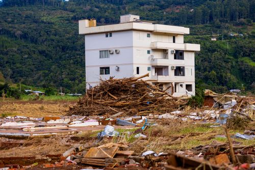 Edifício residencial cercado de troncos e entulho trazidos pela enchente no Vale do Taquari