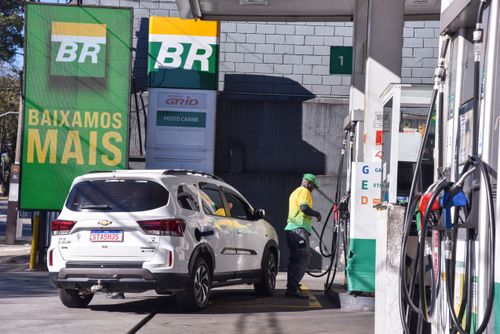 Frentista abastecendo carro em posto de combustíveis