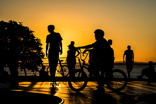 Jovens em pista de skate com o pôr do sol na orla do Guaíba - 