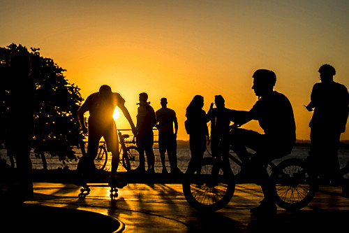 Jovens em pista de skate com o pôr do sol na orla do Guaíba - 