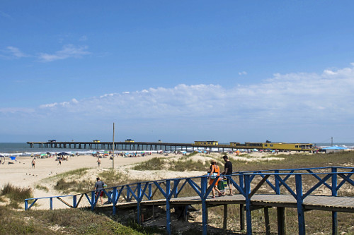 Banhistas atravessam ponte em direção da praia de Tramandaí