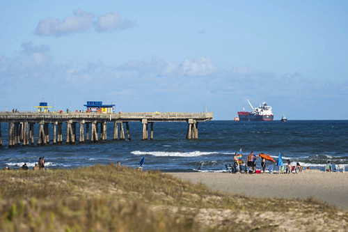 Plataforma marítima e banhistas na praia de Tramandaí