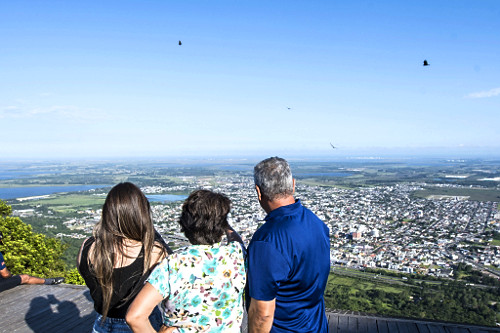 Pessoas observando faixa litorânea da cidade e complexo de lagoas a partir de mirante do morro da Borrússia
