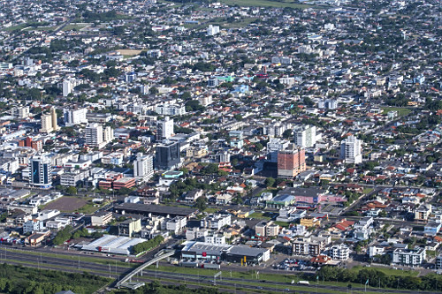 Vista de cima de parte da cidade com rodovia no primeiro plano