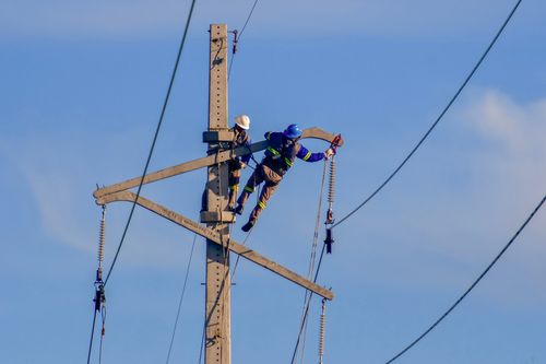 Trabalhadores em obra de expansão e modernização da infraestrutura elétrica e de telecomunicações