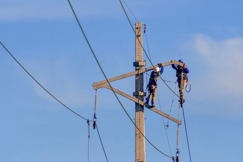 Trabalhadores em obra de expansão e modernização da infraestrutura elétrica e de telecomunicações
