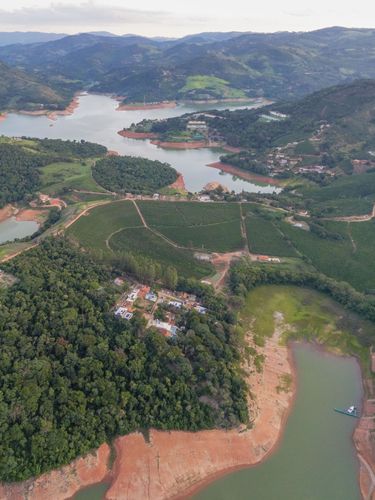 Vista de drone do reservatório da Usina Hidrelétrica formado pelo represamento pelo Rio Pardo com plantaçã