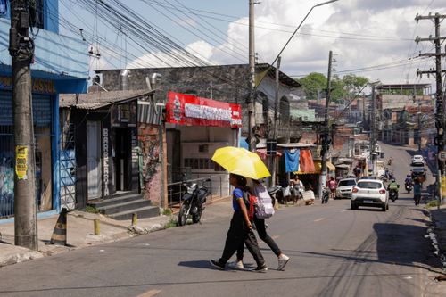Pedestres atravessando rua do bairro Mauazinho