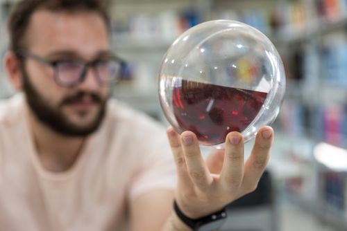 Estudante segura recurso pedagógico de hidrostática para demonstrar o PrincÃpio da Horizontalidade