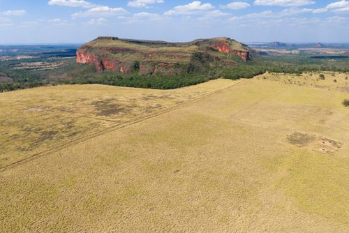 Vista de drone de área de milho recém colhida e morro de arenito da Formação Paredão Grande - ao fundo