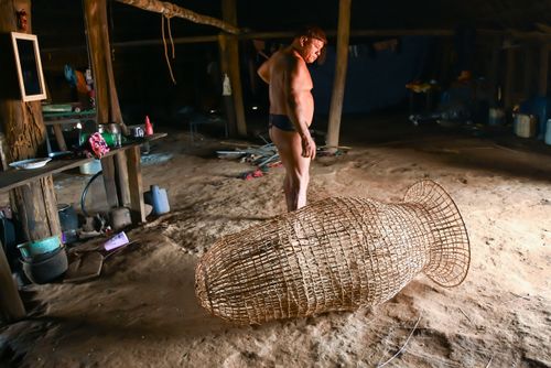 Indígena da etnia Wauja e cesto armadilha covo de cipó para pegar peixe - Parque Indígena do Xingu