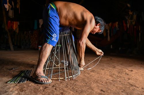 Indígena Waurá amarrando varetas em armadilha kuluto ou matapi de peixes em forma de cone - Parque Indígena