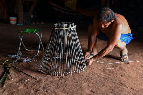 Indígena Waurá amarrando varetas em armadilha kuluto ou matapi de peixes em forma de cone - Parque Indígena