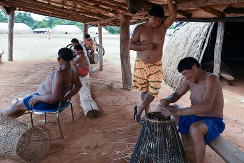 Indígena Waurá amarrando varetas em armadilha kuluto ou matapi de peixes em forma de cone - Parque Indígena