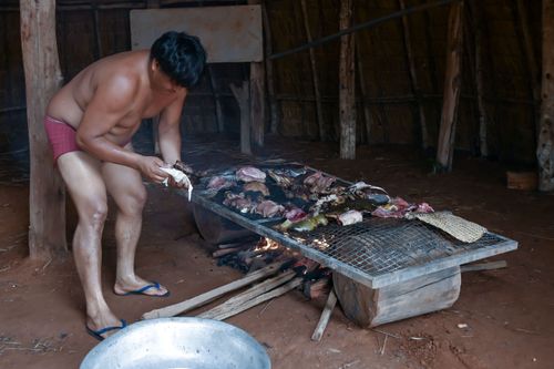 Indígena Waurá da aldeia Piyulaga moqueando peixes - Parque Indígena do Xingu