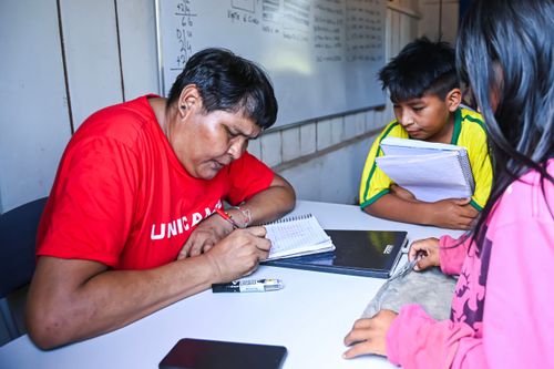 Professor Waurá corrigindo as atividades dos seus alunos na sala de aula - Parque Indígena do Xingu
