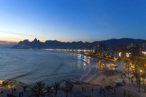 Vista de drone do bairro e praia de Ipanema ao anoitecer - Maciço da Tijuca no fundo