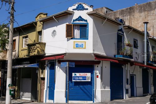 Prédio de uso misto - comércio no andar térreo com anúncio de aluga-se e moradia no andar superior 
