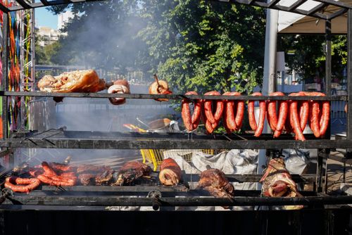 Carnes sendo preparadas em churrasqueira no arraial do Largo da Batata - Festa Junina no Largo de Pinheiros