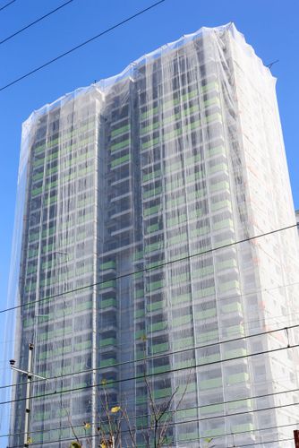 Edifício coberto com tela de proteção durante construção - bairro da Mooca
