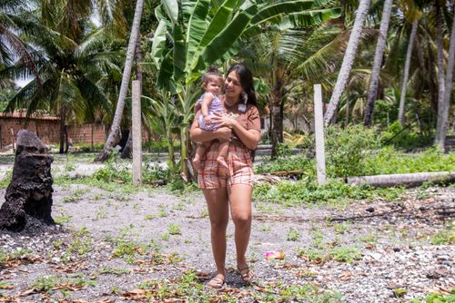 Mulher indígena da aldeia Tramataia da etnia Potiguar com a filha no colo 