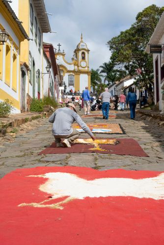 Voluntários decorando a Rua da Câmara com tapetes de serragem durante o Corpus Christi para a passagem da pr