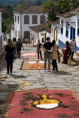 Voluntários decorando rua com tapetes de serragem durante o Corpus Christi para a passagem da procissão do S