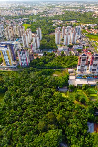 Vista de drone de edifícios residenciais no bairro Aleixo avançando sobre áreas verdes