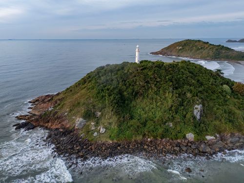 Vista de drone do Farol das Conchas sobre o Morro das Conchas no Parque Estadual da Ilha do Mel - Baía de Par