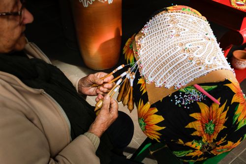 Rendeira produzindo renda de bilro 