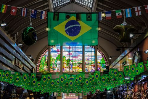 Bandeiras decorando o Mercado Municipal Paulistano Mercadão - ao fundo vitral de Conrado Sorgenicht Filho