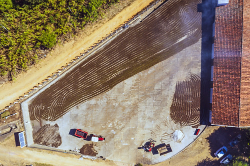 Vista de drone de grãos de café do tipo catuaí vermelho no terreiro para secagem ao sol espalhado por trato