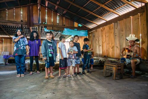 Crianças e cacique da etnia Guarani Mbya entoando os cantos sagrados na Casa de Reza da Aldeia de Retomada Nh