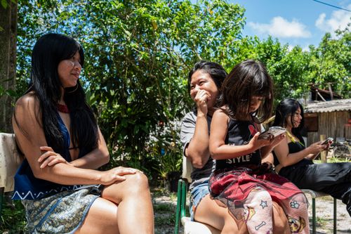 Família indígena da etnia Guarani Mbya usando telefone celular - Aldeia de Retomada Nhanderekoá