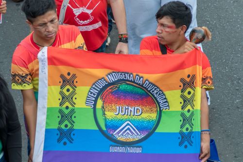 Indígenas com bandeira LGBTQIA+ durante mobilização indígena do 21º ATL Acampamento Terra Livre na Esplan