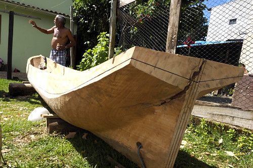 Mestre canoeiro remanescente esculpindo canoa no quintal de sua moradia - Vila de Trindade - 