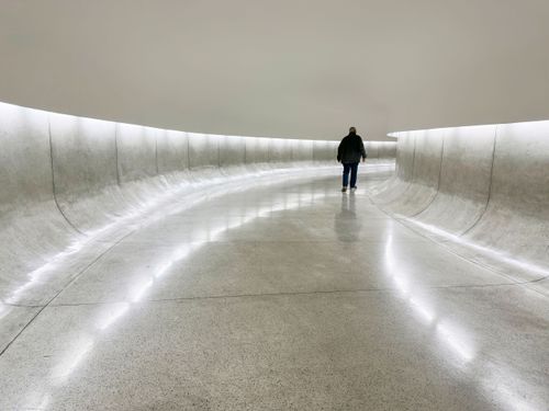 Pessoa no túnel de acesso ao olho e torre no MON Museu Oscar Niemeyer