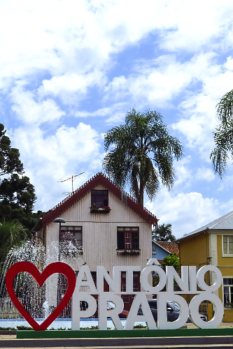 Letreiro eu amo Antônio Prado na Praça Garibaldi e ao fundo moradia com arquitetura típica italiana  - 