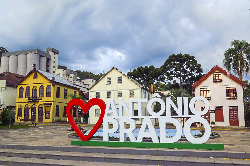 Letreiro eu amo Antônio Prado na na Praça Garibaldi - ao fundo casas com arquitetura típica italiana - a es