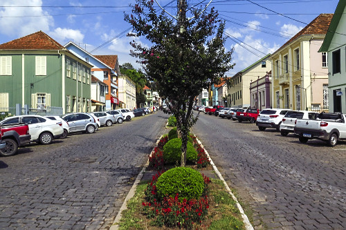Jardim no canteiro central de rua e casas com arquitetura típica italiana no centro da cidade - 
