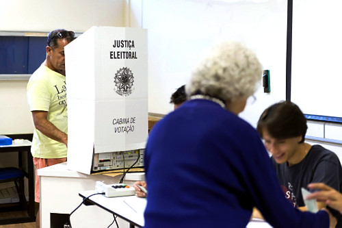Eleitor assina caderno de votação junto ao mesário antes de votar na urna  eletrônica - Eleições 2014 | Pulsar Imagens | Banco imagens do Brasil