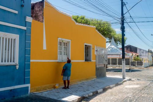 Morador pintando fachada de casa no centro histórico