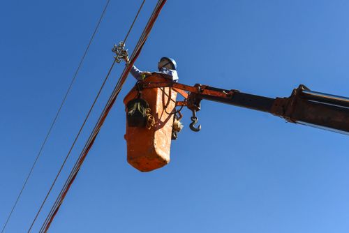 Trabalhador instalando rede elétrica em novo bairro residencial