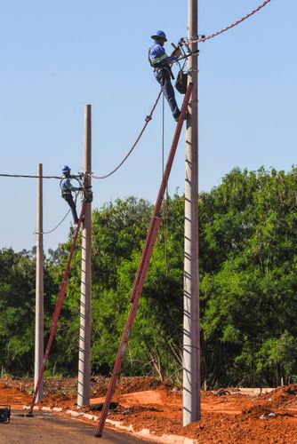Trabalhadores instalando rede elétrica em novo bairro residencial