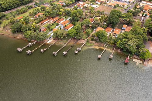 Vista de drone de loteamento residencial e decks de madeira na margem do rio Barra Mansa - Região Turística 
