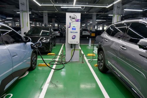 Carros elétricos recarregando suas baterias em vagas exclusivas no estacionamento de supermercado