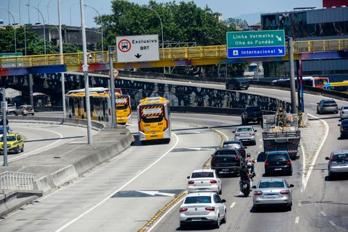 Corredores exclusivos de ônibus BRT Transbrasil e veículos na Avenida Brasil - à direita placa aérea sinal