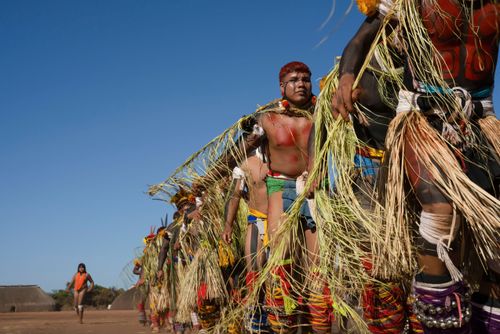 Indígenas Kuikuro da aldeia Ipatse com galhos de palha no ritual de Tawarawana - Parque Indígena do Xingu
