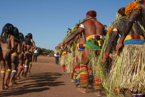Indígenas Kuikuro da aldeia Ipatse com galhos e saias de palha no ritual de Tawarawana - Parque Indígena do 