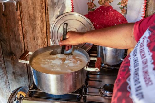 Agricultora preparando coalhada para produzir queijo artesanal em sua moradia no Assentamento Eli Vive - MST M